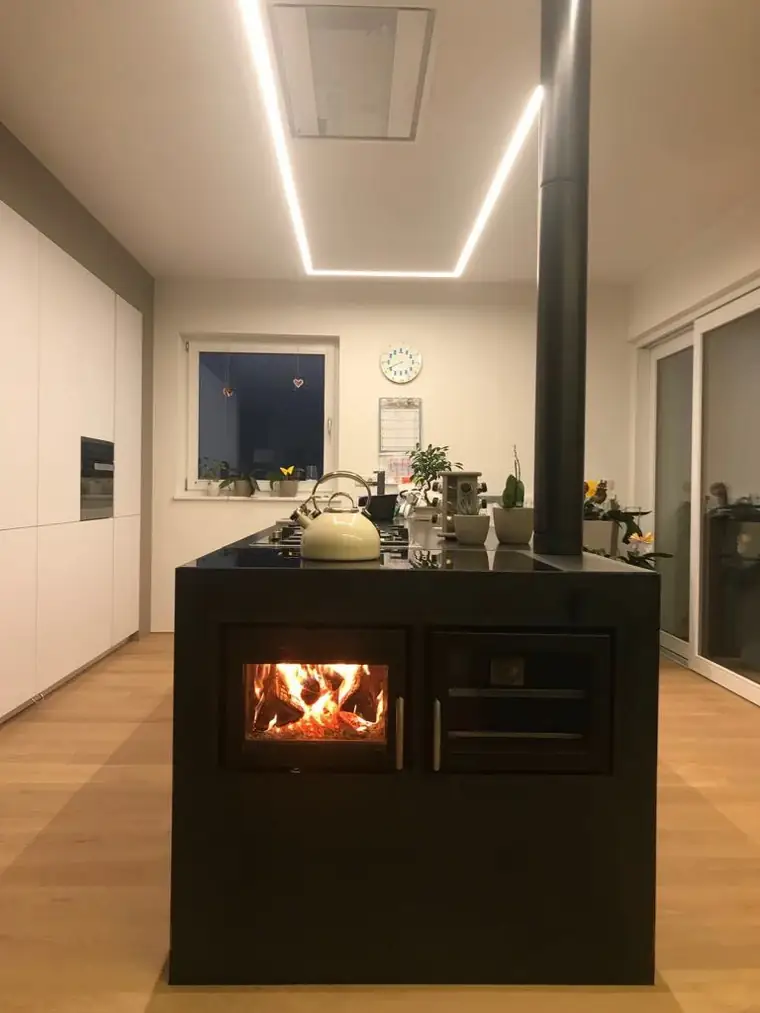 Schwarze Kochinsel mit offenem Feuerraum und Kessel in einer Wohnküche
