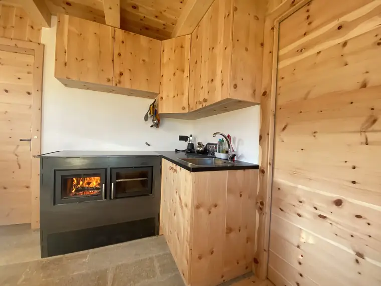 Holzherd eingebaut in eine Küche aus Zirbenholz