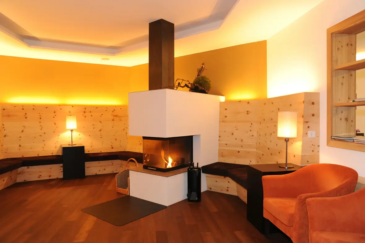 Lounge mit warmem Licht, Kamin und Altholzverkleidung