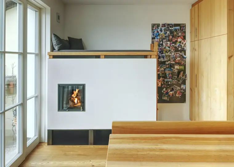 Kamin mit langer Holzbank entlang der Wand