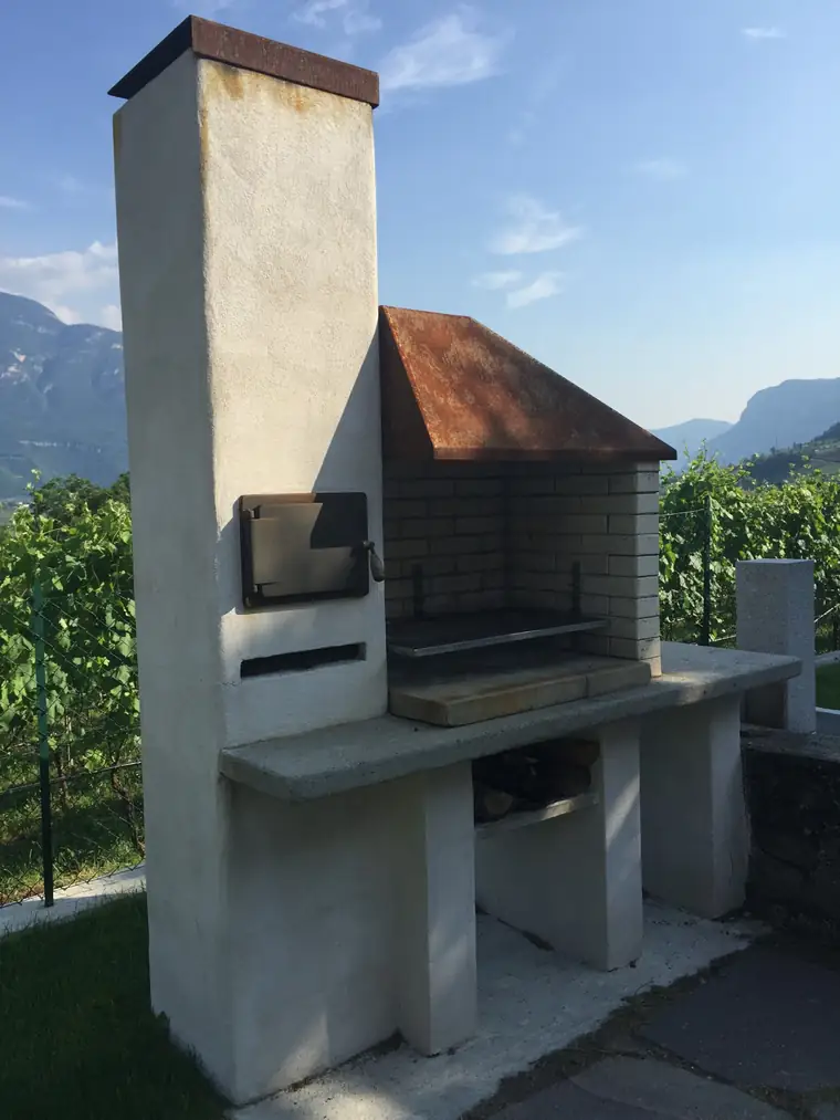 Gemauerter Grillkamin mit Kupferdach vor Weinbergen