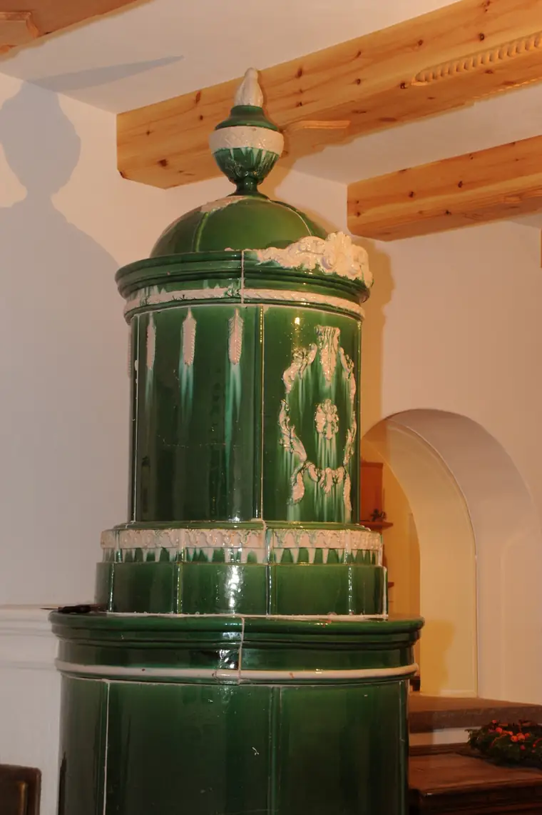 Detail des grünen Säulenofens mit Bekrönung