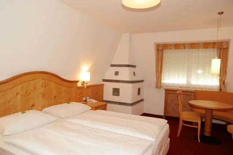 Hotelzimmer mit einem Kachelofen neben dem Bett