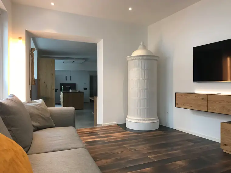 Weißer Säulenofen in einem modernen Wohnraum